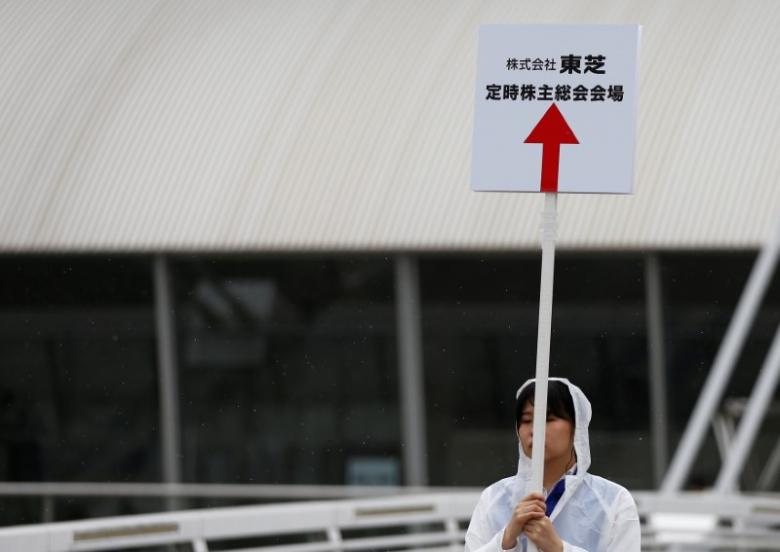 A Staff Member Of Toshiba Corp. Holds A Sign Board Of The Company's Annual Shareholders Meeting At An Entrance Of The Venue In Chiba, Japan