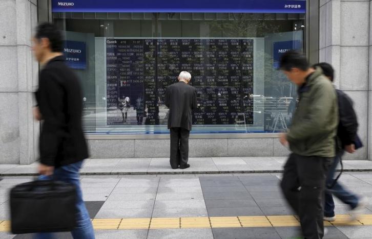 Man Looks At A Stock Quotation Board Outside A Brokerage In Tokyo